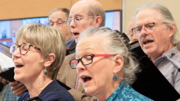 Close-up of women and men singing in choir