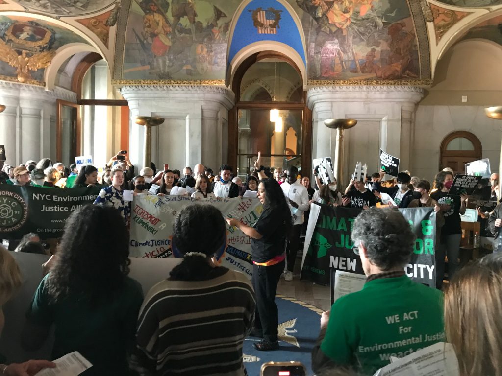 Woman leads Climate Action Rally participants in chants and songs