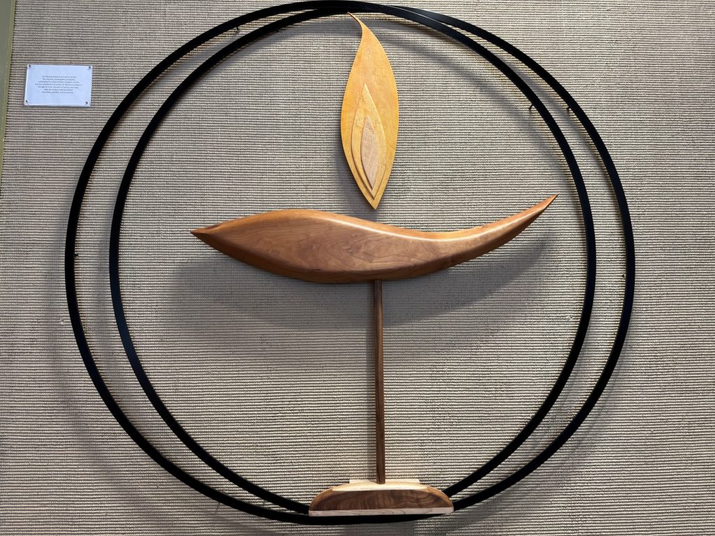 An off-center, flaming chalice with two overlapping circles.