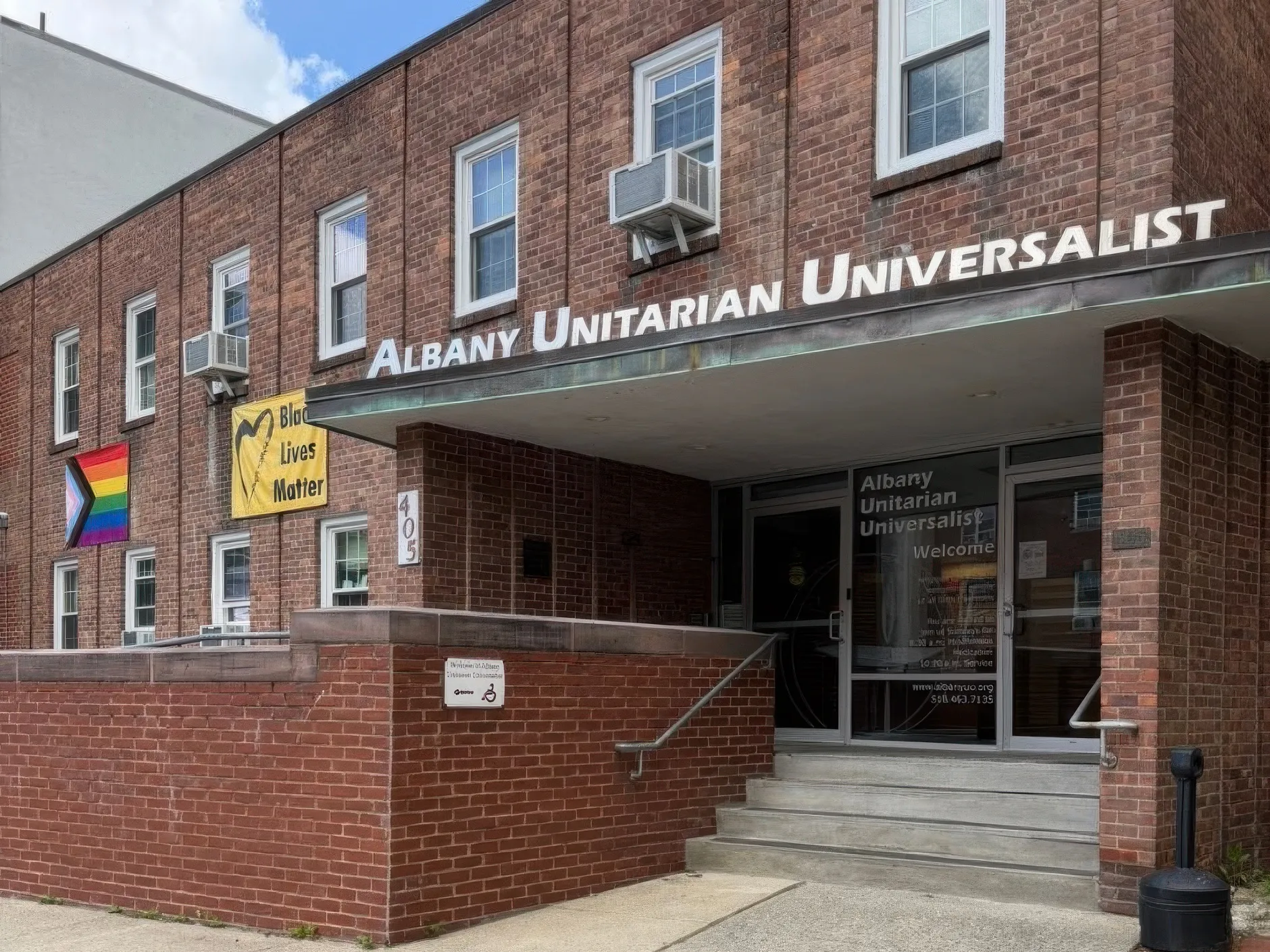 The Albany Unitarian Universalist building entrance with a Pride flag and Black Lives Matter banner