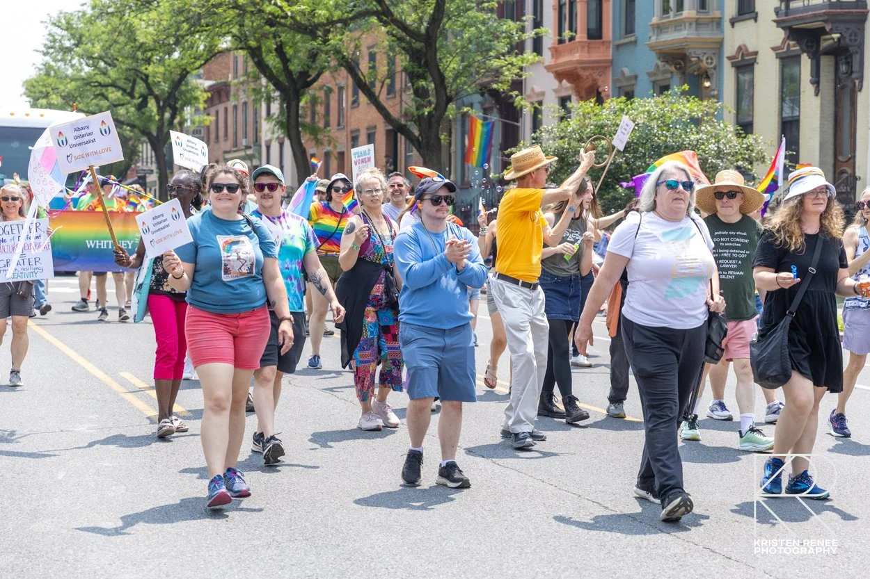 Marchers at the Capital Pride Parade carrying an Albany Unitarian Universalists banner