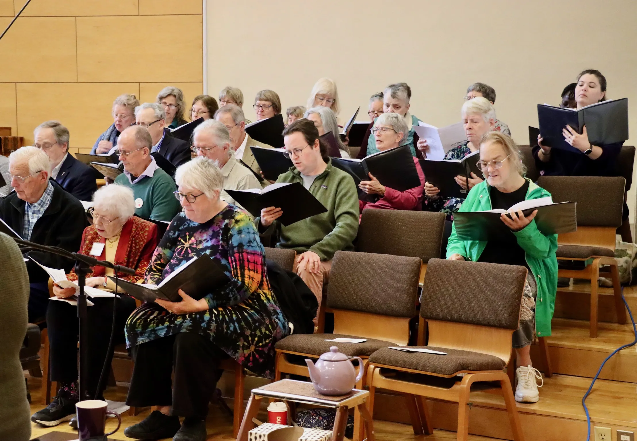 Congregation members singing together in the sanctuary as a pianist plays