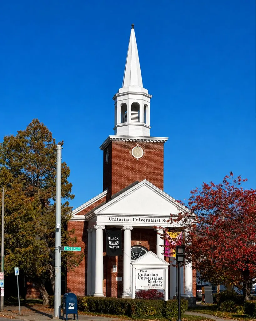 The Unitarian Universalist Society of Albany church building in autumn with fall foliage