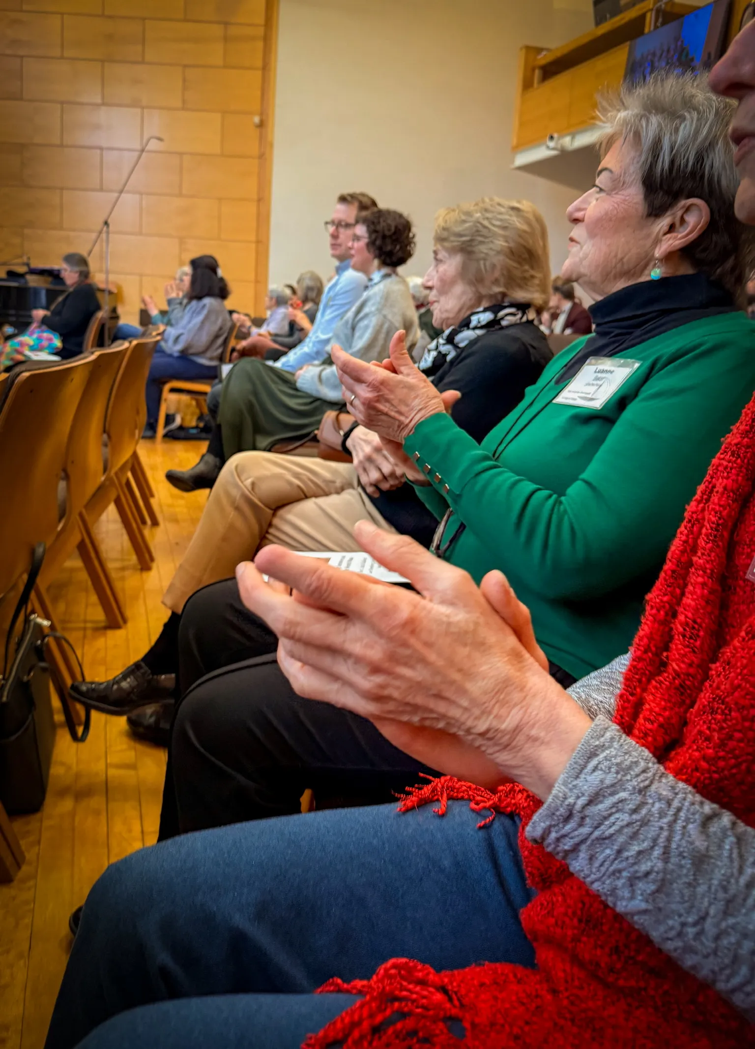 Congregation members clapping and singing together in the sanctuary