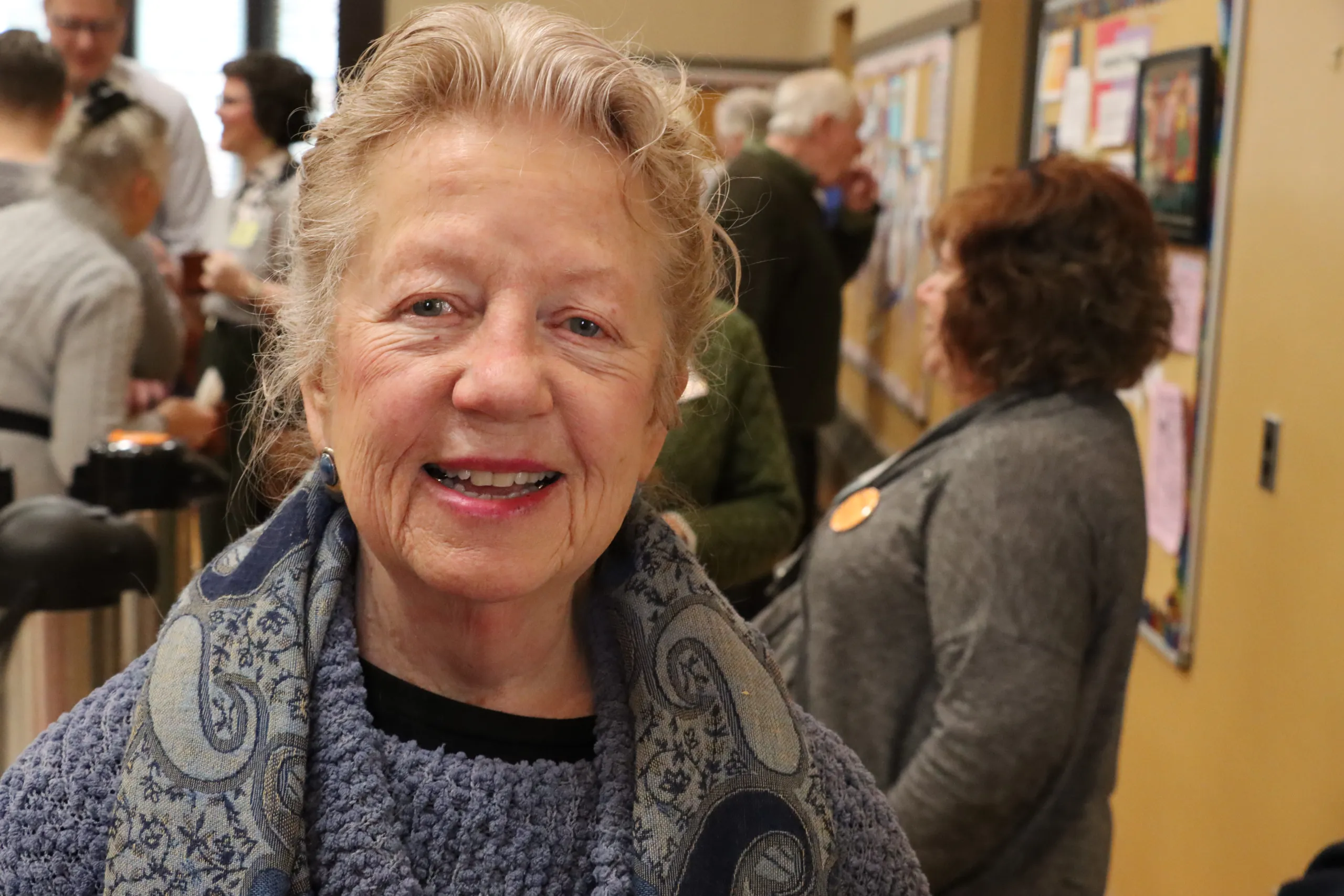 Portrait of a smiling woman wearing a paisley scarf at a church gathering