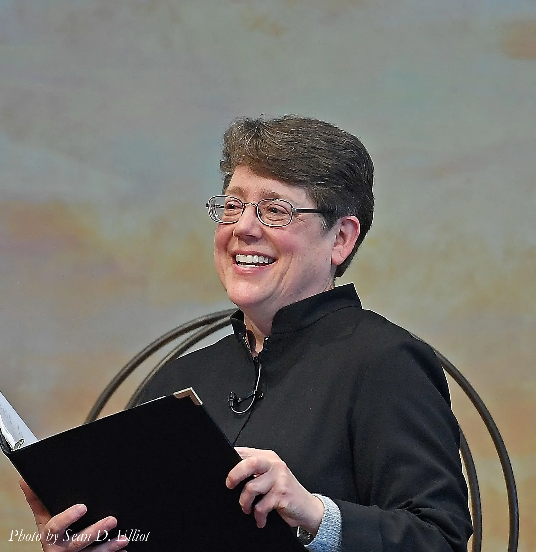 Ann Kadlecek holding a clipboard and microphone