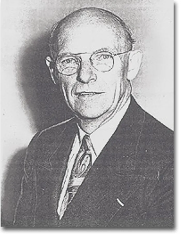 A black-and-white archival portrait photo of a minister in glasses and a suit