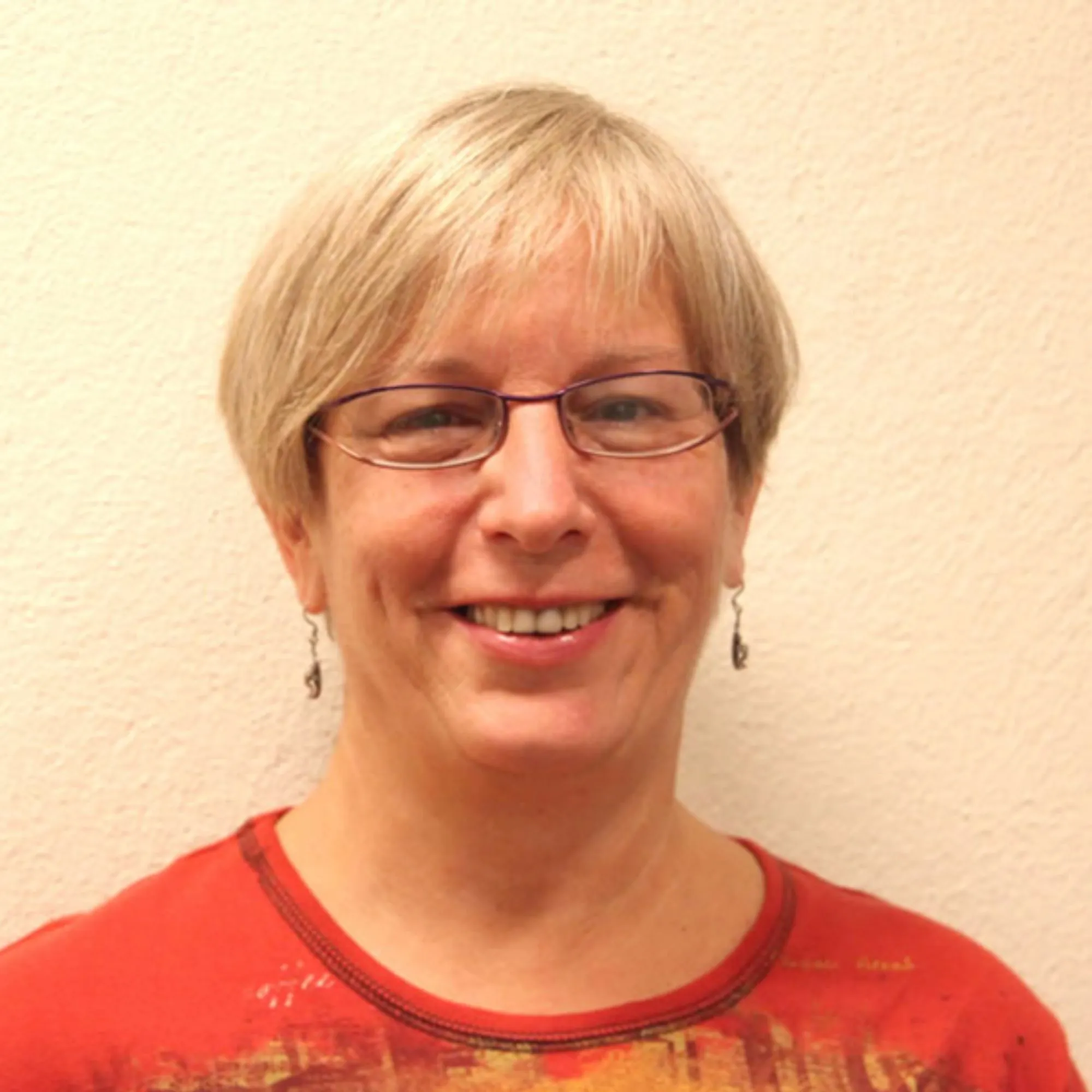 Portrait of Sharon Babala smiling against a plain wall