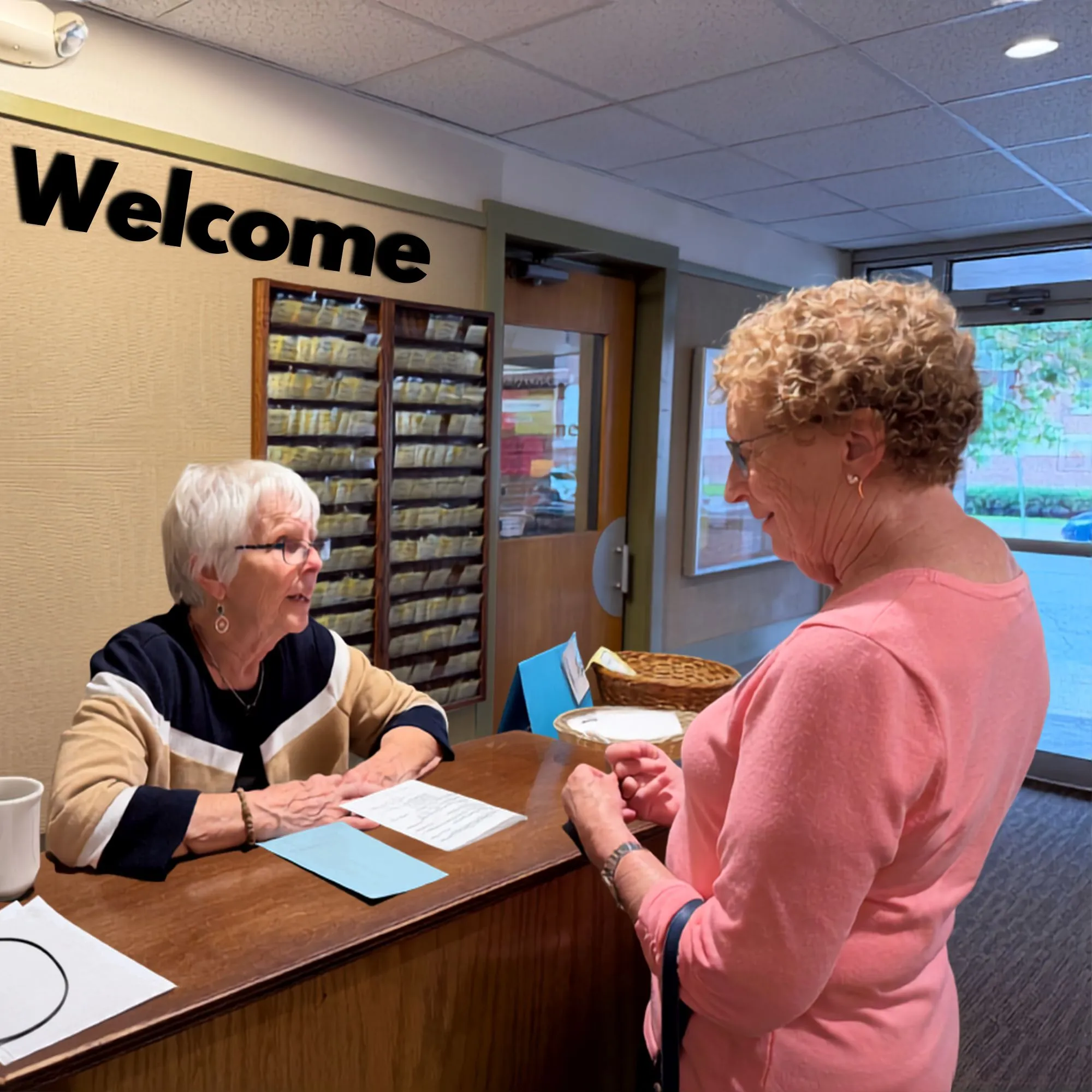 A volunteer greeting a visitor at a welcome desk