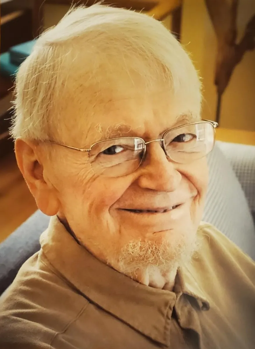 Portrait of Jon Newell, a smiling older man with white hair and glasses